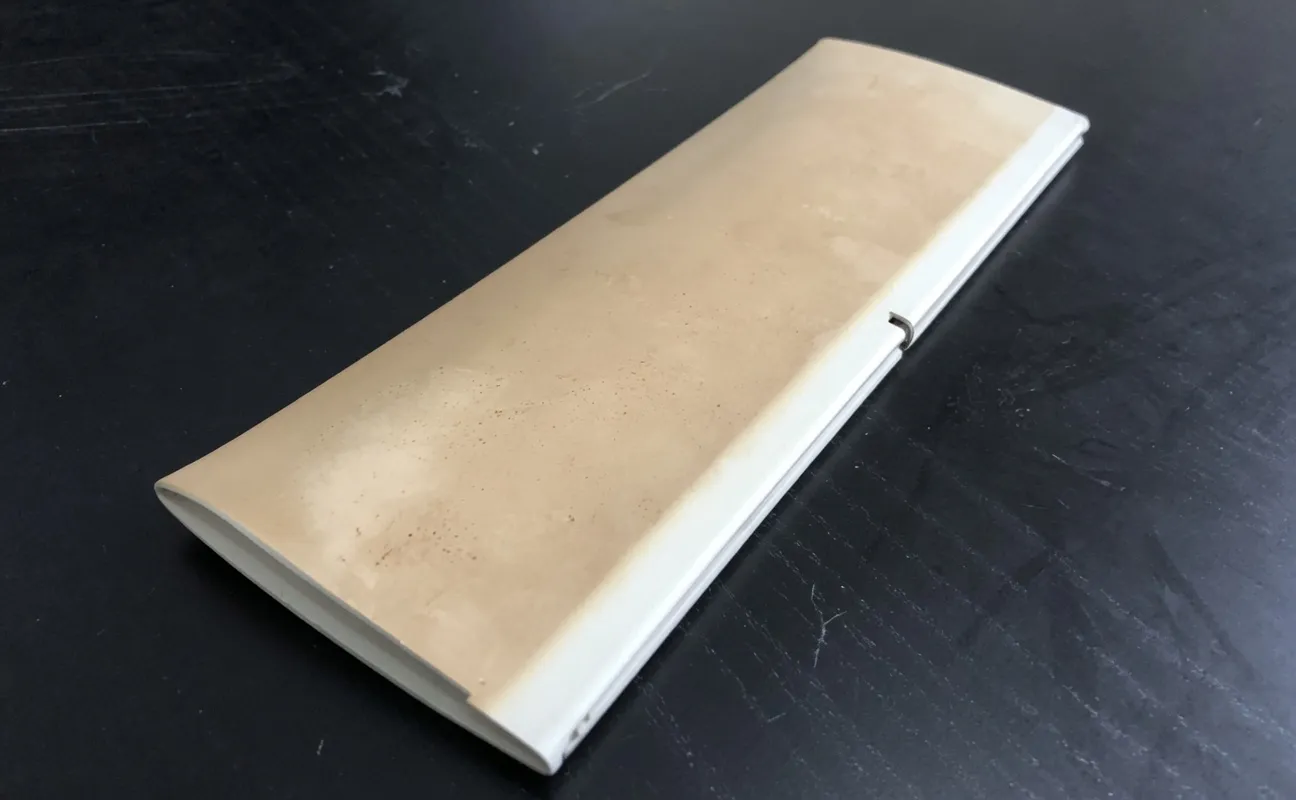 A hollow vinyl shutter louver that has faded and yellowed to a brown tint