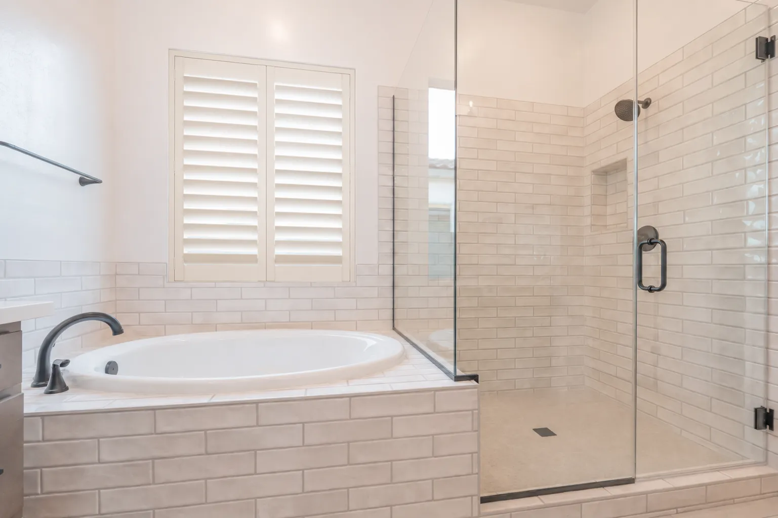 Off-white poly plantation shutters over a bathtub in a San Tan Valley, Arizona bathroom
